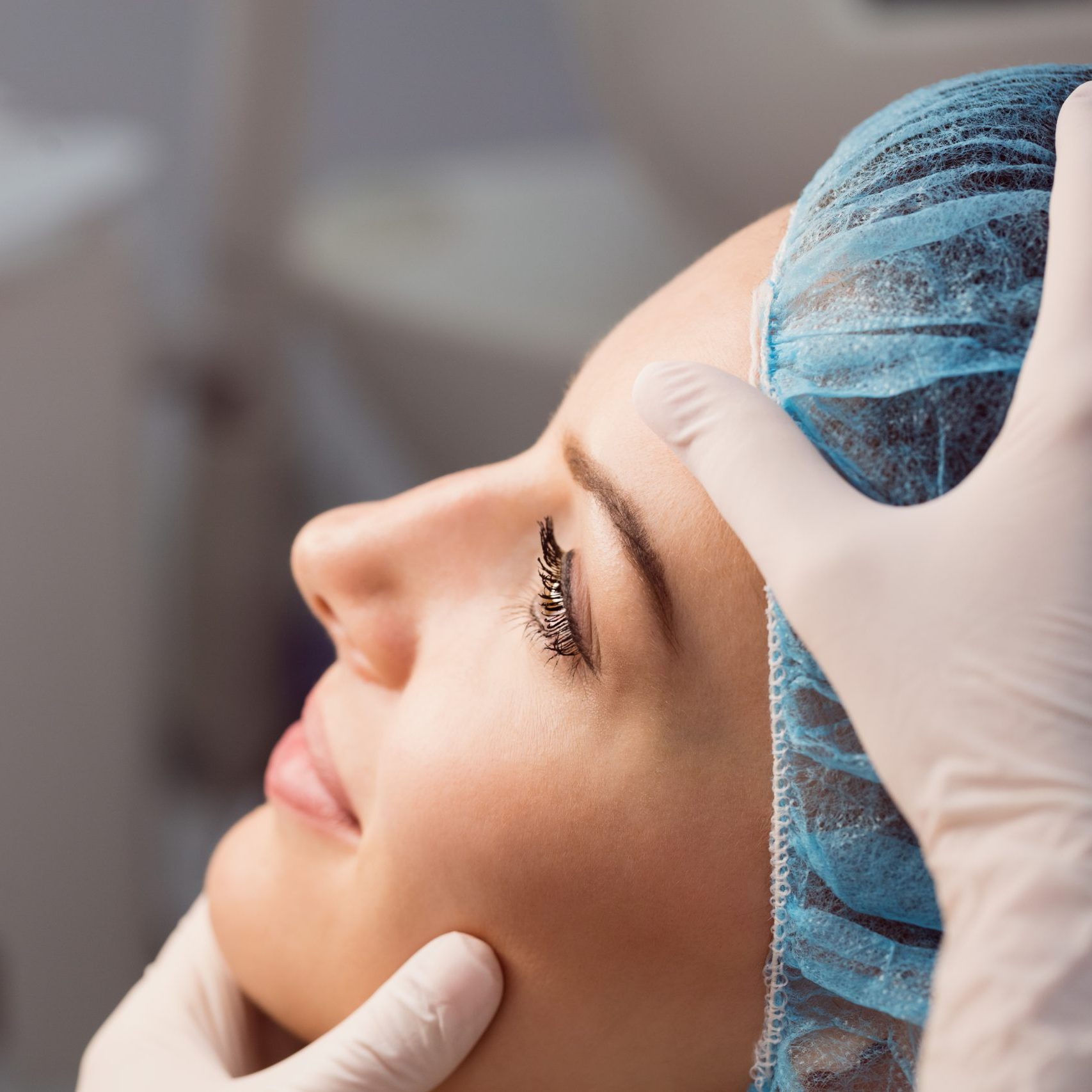 Hands of doctor examining womans face for cosmetic treatment at clinic Medicina estetica Torino